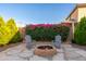 Cozy backyard featuring a brick fire pit, comfortable seating, and vibrant floral landscaping, perfect for relaxing at 12110 W Rowel Rd, Peoria, AZ 85383