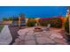Cozy backyard fire pit with seating, surrounded by lush landscaping, a trampoline, and ambient lighting at 12110 W Rowel Rd, Peoria, AZ 85383