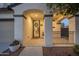 Inviting front porch featuring a security door, stucco columns, and decorative plants in pots at 12110 W Rowel Rd, Peoria, AZ 85383