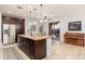 Modern kitchen featuring stainless steel appliances, dark wood cabinetry, and an island with granite countertops at 12110 W Rowel Rd, Peoria, AZ 85383