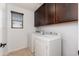 Laundry room with washer, dryer, and ample cabinet space at 12110 W Rowel Rd, Peoria, AZ 85383