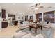 Open-concept living room featuring tile floors, neutral paint, plush sofas, and a ceiling fan, creating a welcoming space at 12110 W Rowel Rd, Peoria, AZ 85383