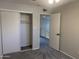 Bedroom featuring a closet with white sliding doors, neutral walls, and plush carpet at 2155 W Farmdale Ave # 8, Mesa, AZ 85202