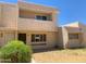Two-story tan townhome featuring desert landscaping, patio, and a brown roof at 2155 W Farmdale Ave # 8, Mesa, AZ 85202