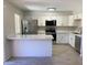 Stylish renovated kitchen featuring new stainless steel appliances, white cabinets, and breakfast bar at 2155 W Farmdale Ave # 8, Mesa, AZ 85202