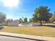 Community pool surrounded by mature trees, grassy areas, and a fenced enclosure at 2155 W Farmdale Ave # 8, Mesa, AZ 85202