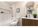 Bathroom with tub, tiled shower, toilet, and sink with wood vanity at 2348 E Diamond Ave, Mesa, AZ 85204