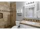 A well-lit bathroom showcasing a tiled shower, toilet, vanity, and a decorative framed mirror at 24615 S 182Nd Pl, Gilbert, AZ 85298