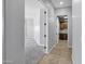 Hallway view of a laundry room with wood cabinets, a tile floor, and gray walls at 24615 S 182Nd Pl, Gilbert, AZ 85298
