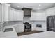 Kitchen featuring stainless steel appliances, white cabinets, quartz countertops, and a gray range hood at 24615 S 182Nd Pl, Gilbert, AZ 85298