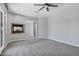 Living room featuring a stone fireplace, ceiling fan, gray carpet, and plenty of natural light at 24615 S 182Nd Pl, Gilbert, AZ 85298