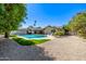 Spacious backyard featuring a pool, covered patio, palm trees, and desert landscaping at 28 E Winged Foot Rd, Phoenix, AZ 85022