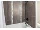 Modern bathroom showcasing tiled walls, tub, and shower featuring sleek black fixtures at 28 E Winged Foot Rd, Phoenix, AZ 85022