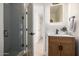 Modern bathroom featuring tiled shower, vanity with sleek black fixtures, and a modern lit mirror at 28 E Winged Foot Rd, Phoenix, AZ 85022