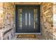 A close-up of the home's modern double door framed by an attractive stone facade and a 'welcome' mat at 28 E Winged Foot Rd, Phoenix, AZ 85022