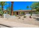 Home exterior features xeriscape landscaping, mature cacti and palm trees, and a modern front door at 28 E Winged Foot Rd, Phoenix, AZ 85022
