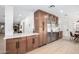 Gourmet kitchen boasts stainless steel appliances, wine fridge, and custom wood cabinetry at 28 E Winged Foot Rd, Phoenix, AZ 85022