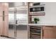 Gourmet kitchen boasts stainless steel appliances, wine fridge, and custom wood cabinetry at 28 E Winged Foot Rd, Phoenix, AZ 85022