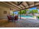 Inviting covered patio with dining set overlooking a refreshing pool and green landscape at 28 E Winged Foot Rd, Phoenix, AZ 85022