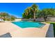 Sparkling blue pool with large deck area, mature landscaping, and clear blue sky at 28 E Winged Foot Rd, Phoenix, AZ 85022
