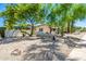 The home's exterior has desert landscaping, mature trees, and unique stone accents throughout the front yard at 28 E Winged Foot Rd, Phoenix, AZ 85022