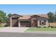 Charming single-story home with stone accents, a well-manicured lawn, and a three-car garage on a sunny day at 3006 E Lucky Horseshoe Ln, San Tan Valley, AZ 85140
