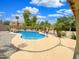 Beautiful in-ground pool with stone accents, surrounded by lush landscaping and palm trees at 31670 N Desert Willow Rd, San Tan Valley, AZ 85143