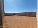 Spacious dirt backyard enclosed by a tall block wall, offering privacy and customization options at 3529 E Audrey Dr, San Tan Valley, AZ 85143
