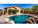 Backyard pool with rock waterfall feature and lush landscaping, perfect for outdoor relaxation at 41598 N Ranch Dr, San Tan Valley, AZ 85140
