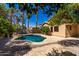 Lush backyard with a beautiful pool, palm trees, and mature landscaping creating a private oasis at 41598 N Ranch Dr, San Tan Valley, AZ 85140