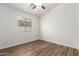Bright bedroom featuring neutral walls, wood-look flooring, a ceiling fan, and natural light at 41598 N Ranch Dr, San Tan Valley, AZ 85140
