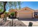 Tan single-story home showcasing a two-car garage, desert landscaping, and low-maintenance front yard at 41598 N Ranch Dr, San Tan Valley, AZ 85140