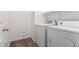 Bright laundry room features modern washer, dryer, and storage shelving for efficient organization at 41598 N Ranch Dr, San Tan Valley, AZ 85140