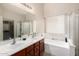 Bright bathroom featuring a double vanity, soaking tub, and glass-enclosed shower at 41847 W Sparks Ct, Maricopa, AZ 85138