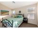 Bright bedroom featuring a decorative bedframe, comfortable bedding, and sunlit windows at 41847 W Sparks Ct, Maricopa, AZ 85138
