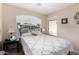 Bright bedroom featuring a wrought iron bed, cheerful quilt, and ample natural light at 41847 W Sparks Ct, Maricopa, AZ 85138