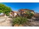 Attractive single-story home surrounded by desert landscaping with rocks, cactus, and a lush green tree at 41847 W Sparks Ct, Maricopa, AZ 85138