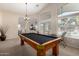 Spacious game room with a well-maintained pool table, natural light, and view to outside at 41847 W Sparks Ct, Maricopa, AZ 85138