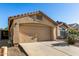 Spacious two-car garage of a tan single-story home with desert landscaping and tiled roof at 41847 W Sparks Ct, Maricopa, AZ 85138