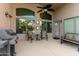 A covered patio featuring a grill, outdoor seating, ceiling fan, and views to the backyard at 41847 W Sparks Ct, Maricopa, AZ 85138