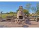 Inviting patio with stone fireplace and outdoor seating, perfect for relaxing and entertaining with views of the golf course at 41847 W Sparks Ct, Maricopa, AZ 85138
