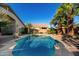 Backyard pool surrounded by lush landscaping and palm trees, creating a private oasis at 41847 W Sparks Ct, Maricopa, AZ 85138