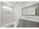 Modern bathroom with a marble countertop, updated shower, and sleek gray vanity at 4307 E Walatowa St, Phoenix, AZ 85044