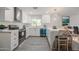 Bright kitchen with white cabinets, stainless steel appliances, quartz countertops, and a dining area at 4307 E Walatowa St, Phoenix, AZ 85044