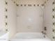 Bathtub shower area featuring a white tile finish and a rainfall shower head with matching neutral colored fixtures and tiling at 4527 E Sunrise Dr, Phoenix, AZ 85044
