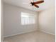 Bright bedroom featuring neutral colored walls, tile flooring, a ceiling fan and large window that brings in tons of natural light at 4527 E Sunrise Dr, Phoenix, AZ 85044