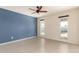 Bedroom featuring a blue accent wall, ceiling fan, and windows overlooking the pool at 4527 E Sunrise Dr, Phoenix, AZ 85044
