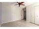 Bedroom featuring neutral colors, a ceiling fan and tile flooring includes an open closet space with additional bedroom door at 4527 E Sunrise Dr, Phoenix, AZ 85044