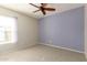 Bedroom features a light color scheme with a large window, a ceiling fan for cooling and tile floors for easy maintenance at 4527 E Sunrise Dr, Phoenix, AZ 85044