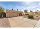 Spacious driveway leading to a single-story home with desert landscaping and an attached two-car garage at 4527 E Sunrise Dr, Phoenix, AZ 85044